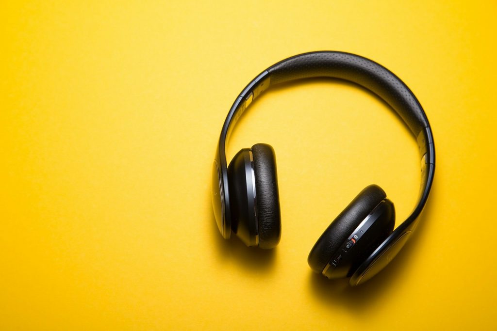 Auriculares negros sobre fondo amarillo. Claves para el social listening.